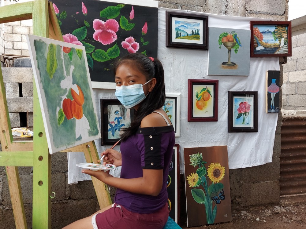 Niña artista vende cuadros en pintura para ayudar a sus padres